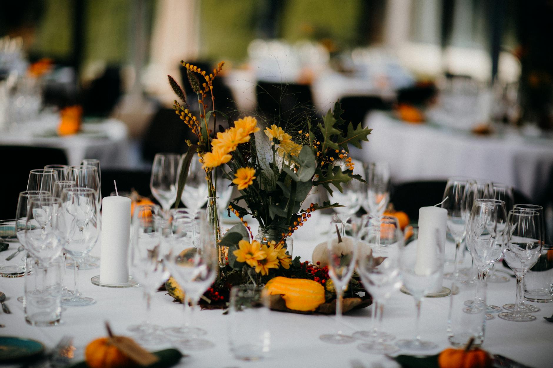 Charming autumn-themed table setup featuring floral centerpiece and glassware. Ideal for festive dining.