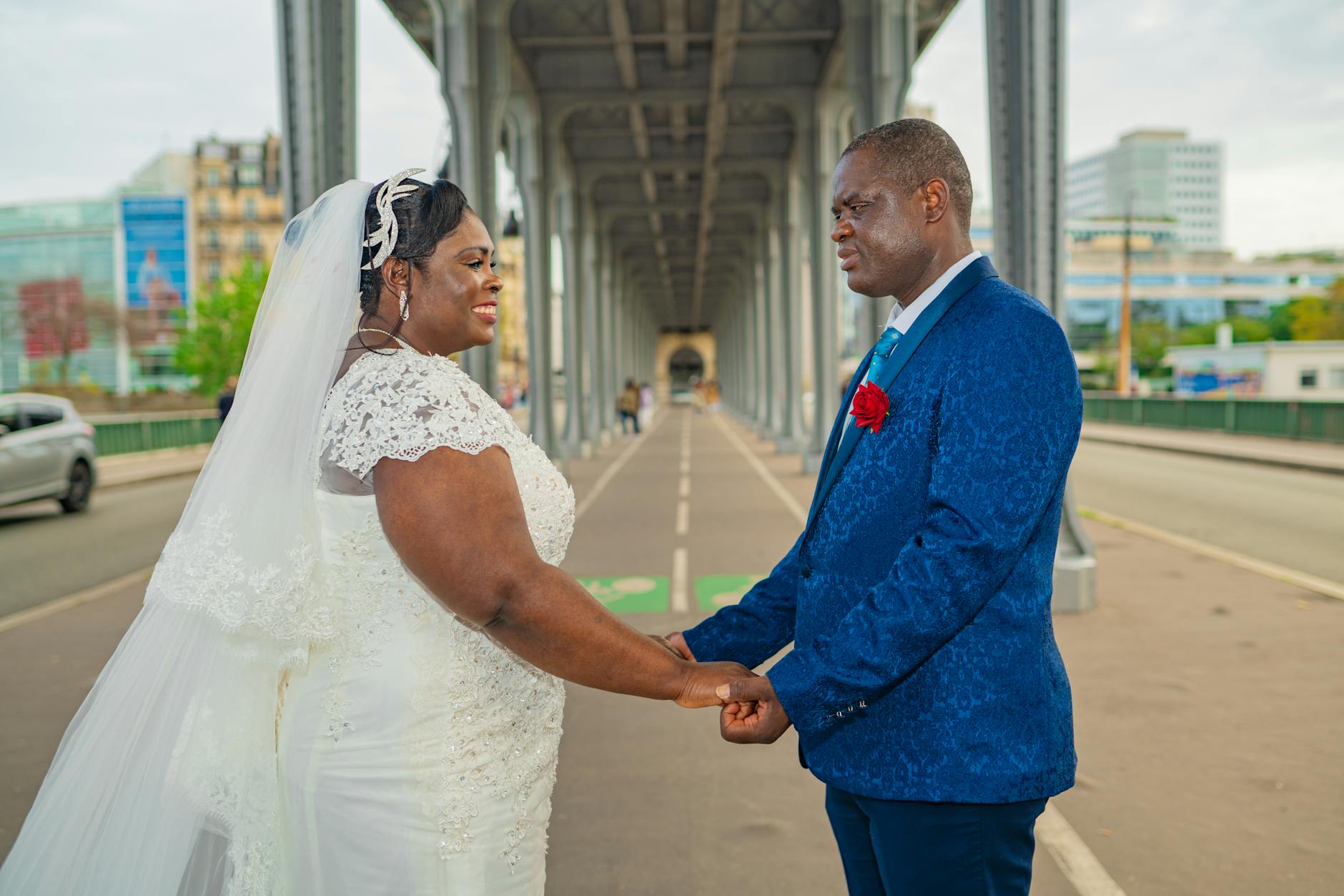 A joyful couple holding hands during their wedding in Paris, captured under an iconic bridge.