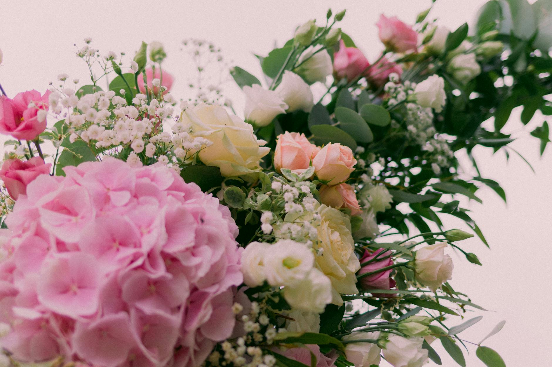 Beautiful floral bouquet featuring hydrangeas, roses, and greenery in soft pastel shades.