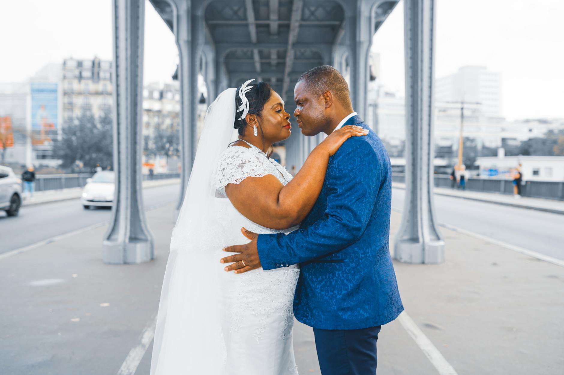 Elegant wedding couple embracing on a Paris bridge, symbolizing love and togetherness.