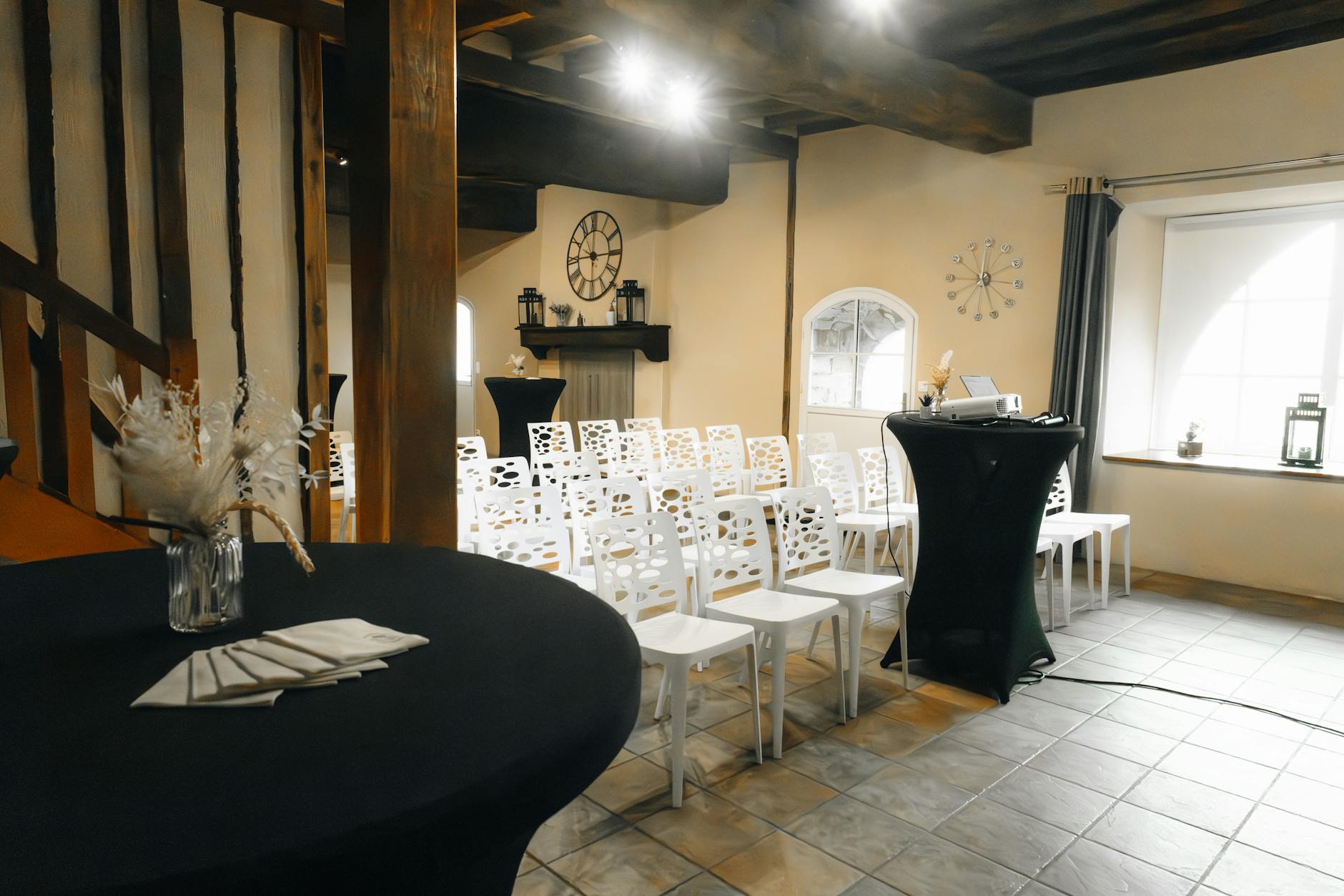 Charming indoor venue with white chairs, elegant decor, and a rustic feel, perfect for intimate events.
