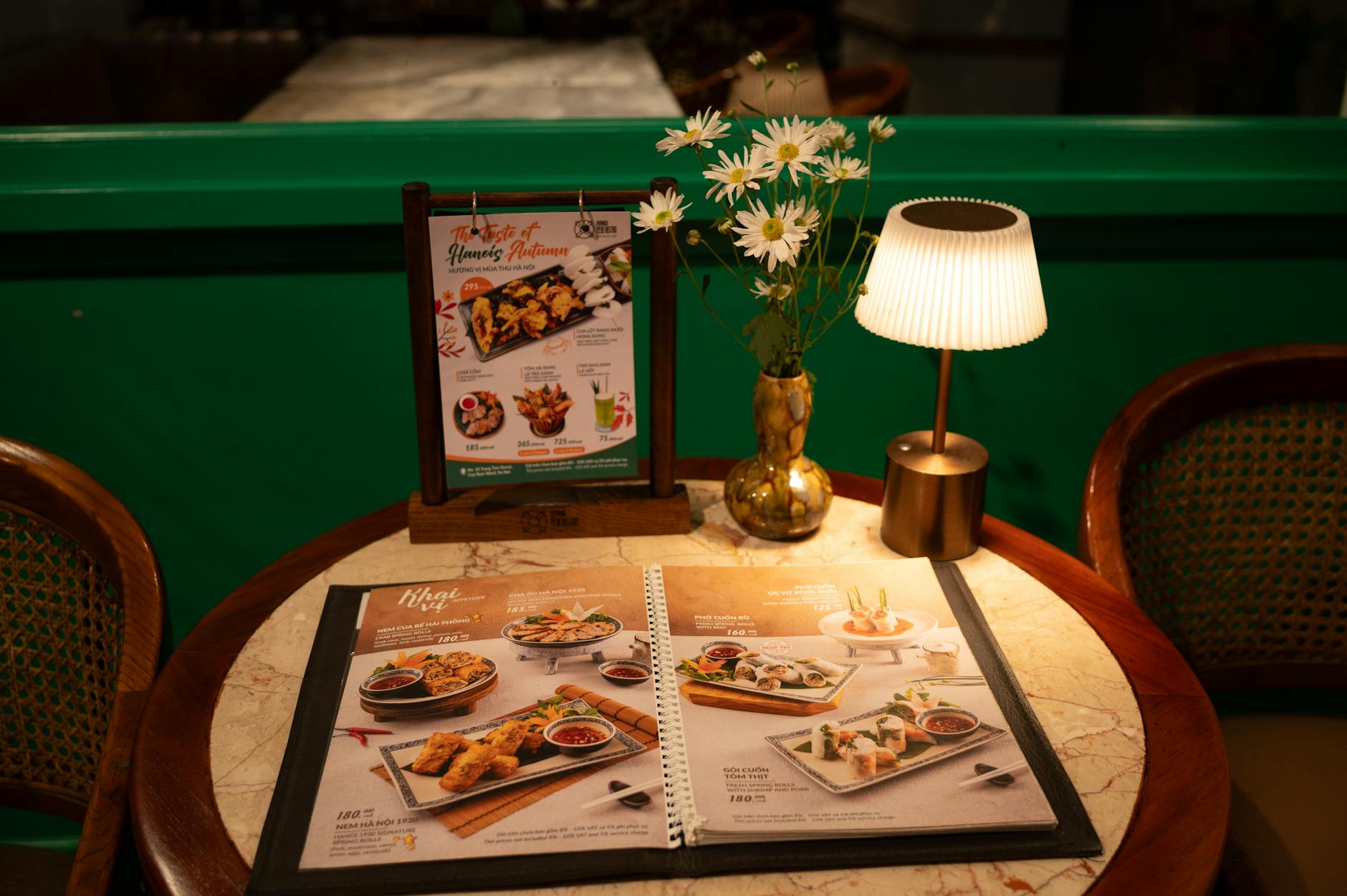 Warm ambiance at restaurant table with menu, flowers, and soft lighting.