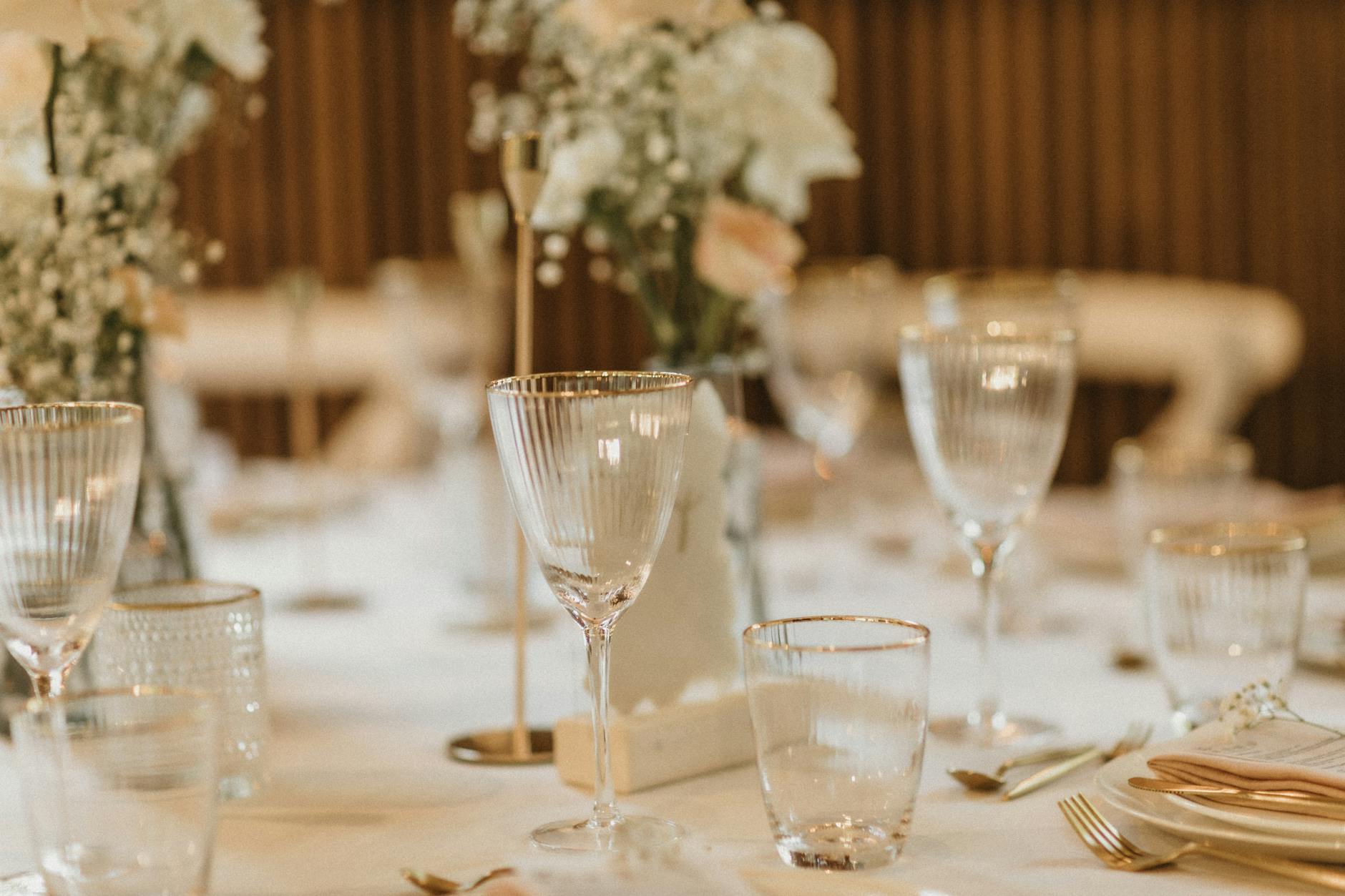 Stylish table setting in a restaurant featuring glassware and delicate floral arrangements.